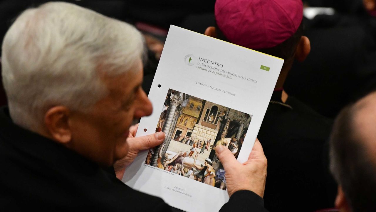 A cardinal holds the liturgy booklet during the opening of the Vatican meeting. 