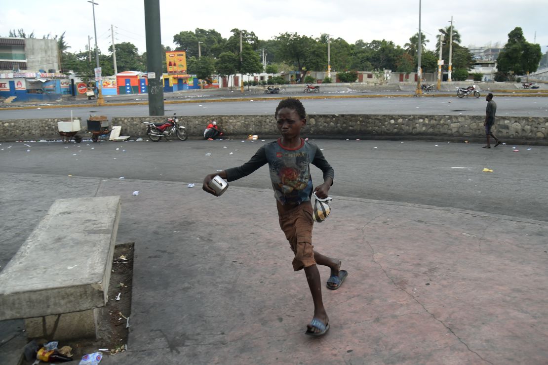 A boy flees from tear gas during clashes with Haitian police in Port-au-Prince on February 15, 2019.