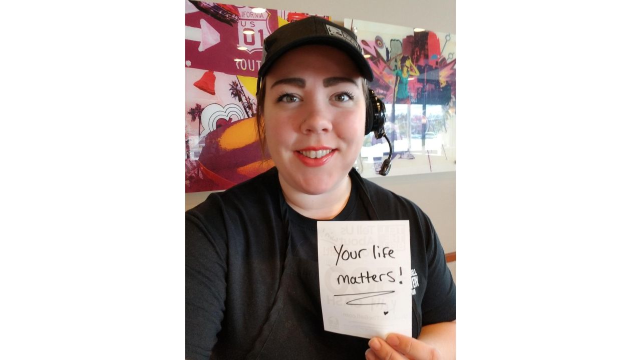 27-year-old Kelly Stewart hands out inspirational notes to her customers at this Syracuse, New York, Taco Bell. 