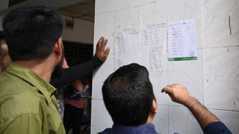 People search for their relatives' names on a list of people who were injured when a fire broke out in Dhaka.