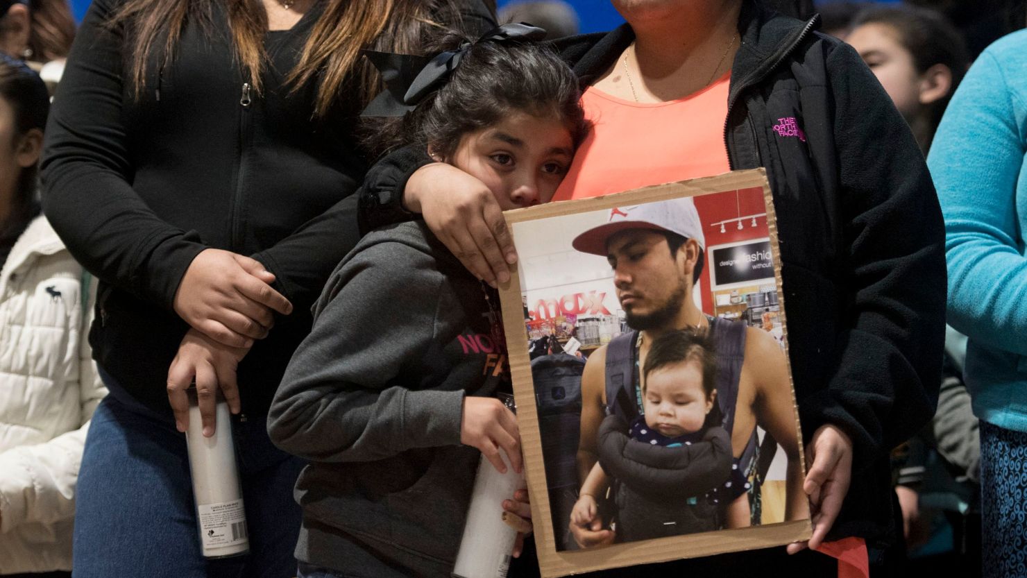 Esmeralda Bautista stands at a vigil last year with a photograph of her brother Luis Bautista-Martinez, one of the workers detained when ICE raided a Tennessee meatpacking plant.