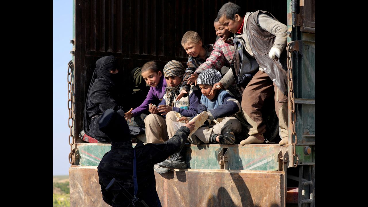 A fighter from the US-backed Syrian Democratic Forces gives bread to children near Baghouz Al-Fawqani, Syria, on Wednesday, February 20. The SDF recently <a href="https://www.cnn.com/2019/02/16/middleeast/syria-isis-caliphate-sdf-intl/index.html" target="_blank">launched an offensive</a> to oust ISIS from its last enclave in Syria. <a href="https://www.cnn.com/interactive/2019/02/world/syria-isis-cnnphotos/index.html" target="_blank">Read more: On the front lines in the fight against ISIS</a>