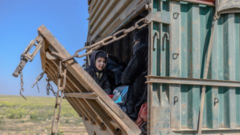 A truck carrying children on February 20, 2019, as a convoy of vehicles believed to be surrendering ISIS members is escorted by SDF fighters out of Baghouz.
