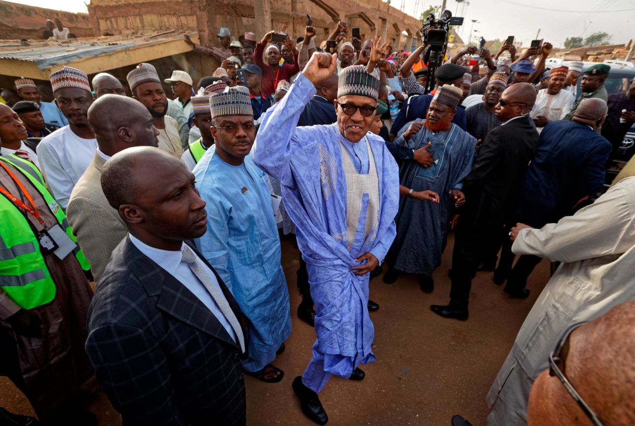 Nigeria's President, Muhammadu Buhari, gestures to supporters after casting his vote in his hometown of Daura.