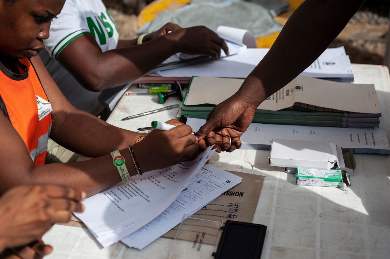 A staff member of the Independent National Electoral Commission marks the thumb of a voter at a polling unit in Lagos.