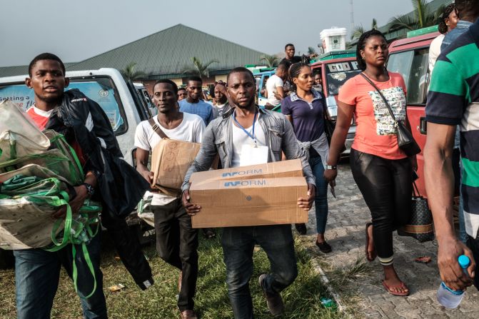 Electoral commission staff deliver items to a polling station in Port Harcourt after voting was due to begin.
