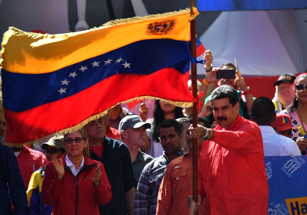 Maduro waves the national flag during a pro-government march in Caracas on February 23. During the rally at the Venezuelan capital, Maduro told supporters he is breaking all diplomatic relations with Colombia and is calling for its ambassadors and consuls to leave Venezuela. Maduro recently began a second term after a 2018 vote that his political opposition and many in the international community denounced as a sham.