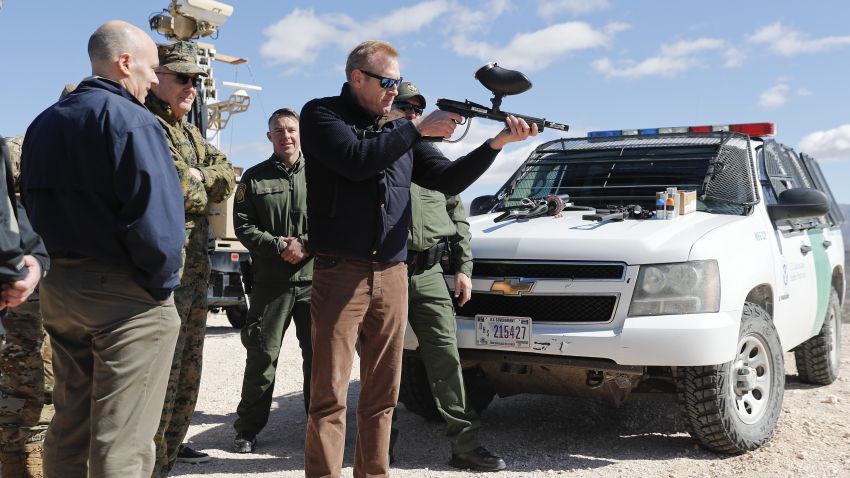 Acting Secretary of Defense Patrick Shanahan, center, fires a modified painted ball gun during a tour of the US-Mexico border at Santa Teresa Station in Sunland Park, N.M., Saturday, Feb. 23, 2019. Standing behind Shanahan is Joint Chiefs Chairman Gen. Joseph Dunford. Top defense officials toured sections of the U.S.-Mexico border Saturday to see how the military could reinforce efforts to block drug smuggling and other illegal activity, as the Pentagon weighs diverting billions of dollars for President Donald Trump's border wall. (AP Photo/Pablo Martinez Monsivais)