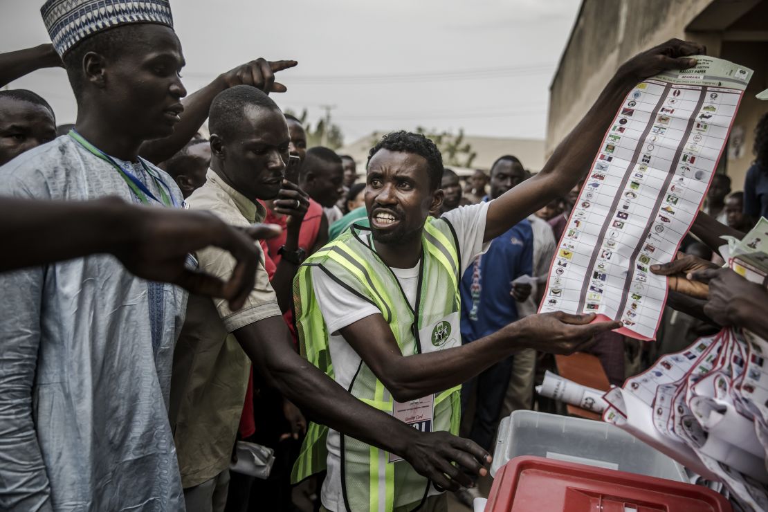 Electoral commission officers and voters talk while votes are counted at a polling station in Yola, Adamawa State, after Saturday's vote.