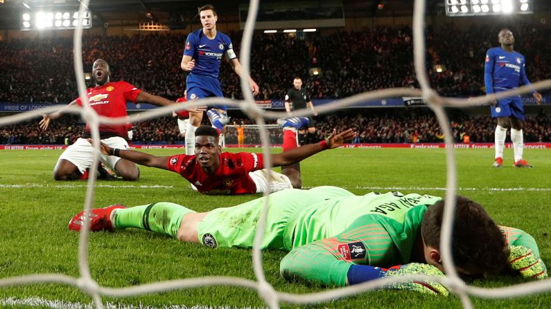 Manchester United players Romelu Lukaku, left, and Paul Pogba celebrate a goal in front of Chelsea goalkeeper Kepa Arrizabalaga on Monday, February 18. United defeated Chelsea 2-0 in London to advance to the quarterfinals of the FA Cup. Chelsea won the competition last season.