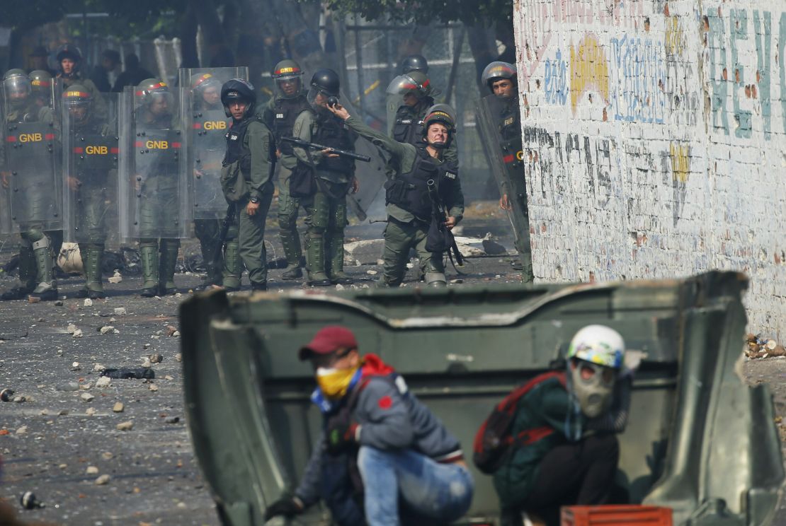 A Venezuelan Bolivarian National Guard officer throws a teargas grenade towards demonstrator in Urena Saturday.
