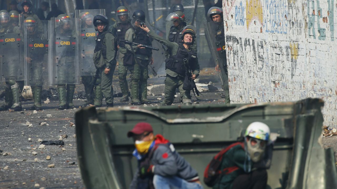 A Venezuelan Bolivarian National Guard officer throws a teargas grenade towards demonstrator in Urena Saturday.