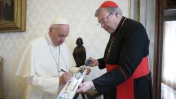 Pope Francis signs a cricket bat he received from Cardinal George Pell, at the Vatican Thursday, Oct. 29, 2015. Pope Francis has received an unusual gift aimed at boosting relations between the Catholic and Anglican churches: A cricket bat signed by the Archbishop of Canterbury and his team following their recent rematch with the Vatican's XI on Rome's Campanelle grounds. Australian Cardinal George Pell, a former rugby player who nevertheless knows cricket, gave Francis the bat Thursday after the St. Peter's Cricket Club beat the Church of England's XI by 43 runs in a 20-over match this weekend. (L'Osservatore Romano/Pool Photo via AP)