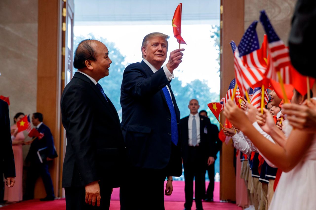 Trump holds a Vietnamese flag while meeting with Vietnamese Prime Minister Nguyen Xuan Phuc, left, on February 27.