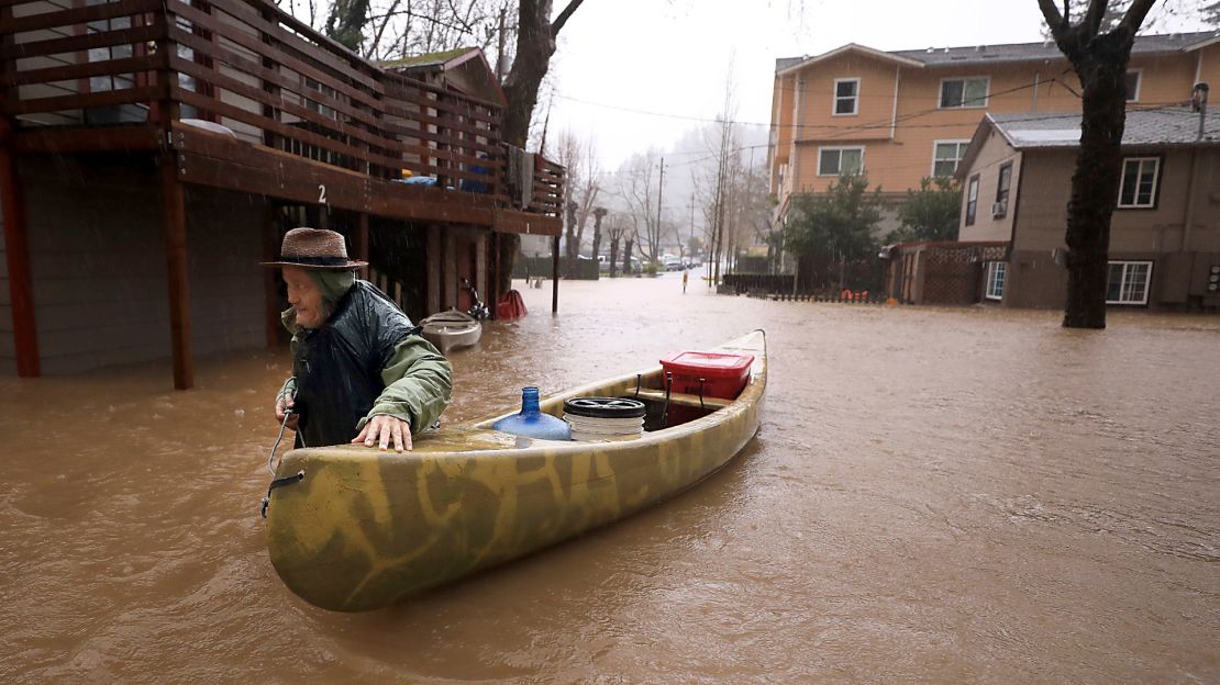Jesse Hagan evacuates to higher ground Tuesday at an apartment complex in Guerneville. 