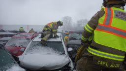 Firefighters climb over vehicles in Sunday's chain-reaction crashes.