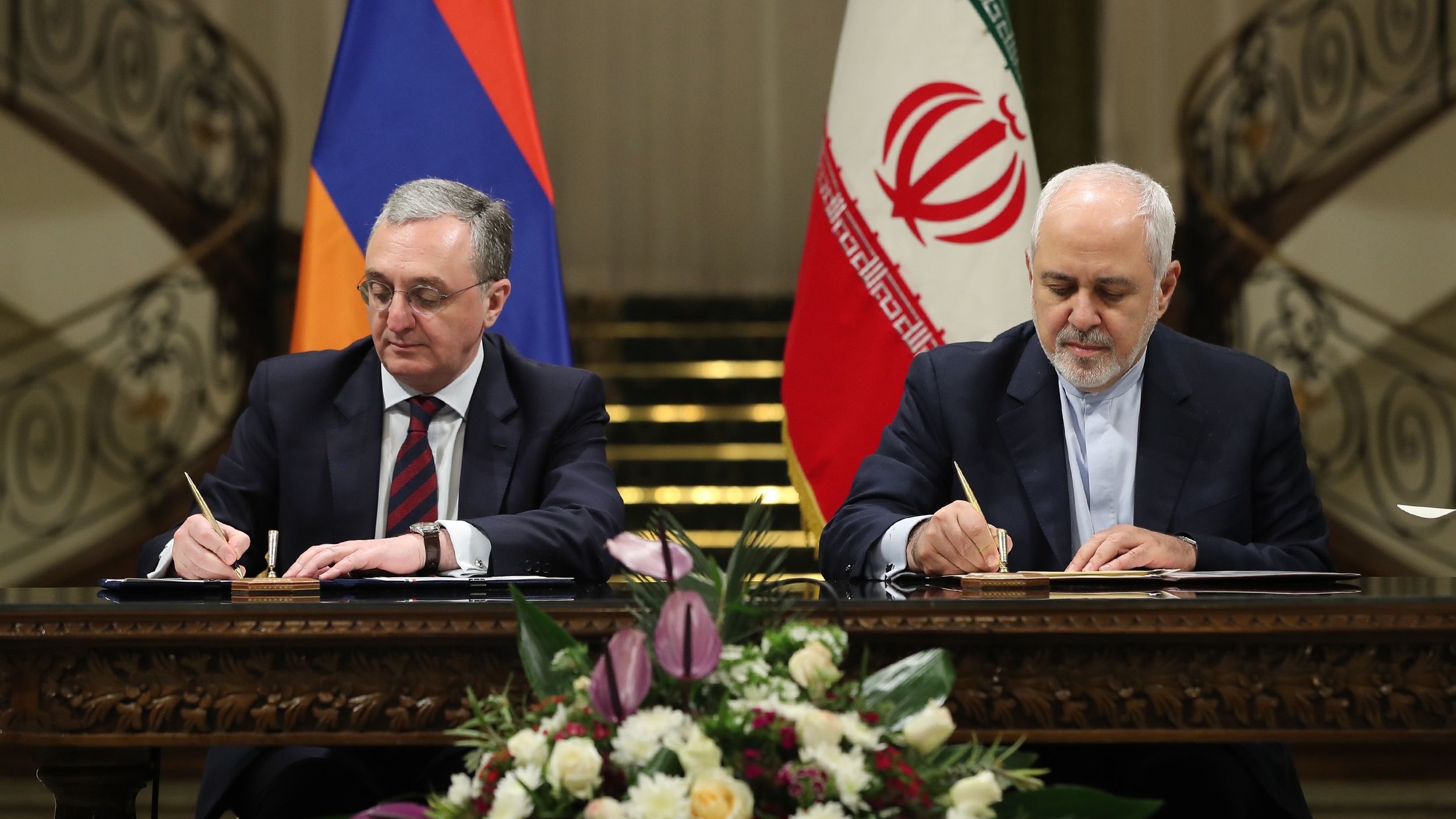 Iran's Foreign Minister Mohammad Javad Zarif, right, signs official documents with Armenian Minister of Foreign Affairs Zohrab Mnatsakanyan.