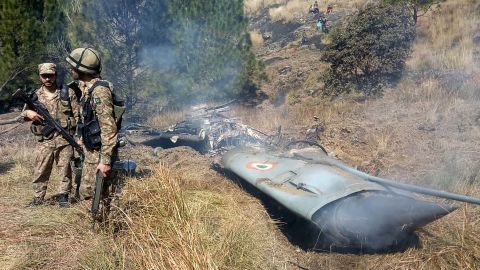Pakistani soldiers stand next to what Pakistan says is the wreckage of a downed Indian fighter jet on February 27.