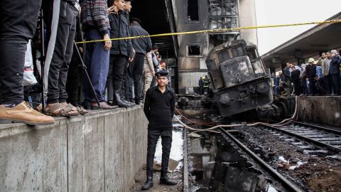 A policeman stands next to wreckage on the tracks after the accident at the Cairo train station.