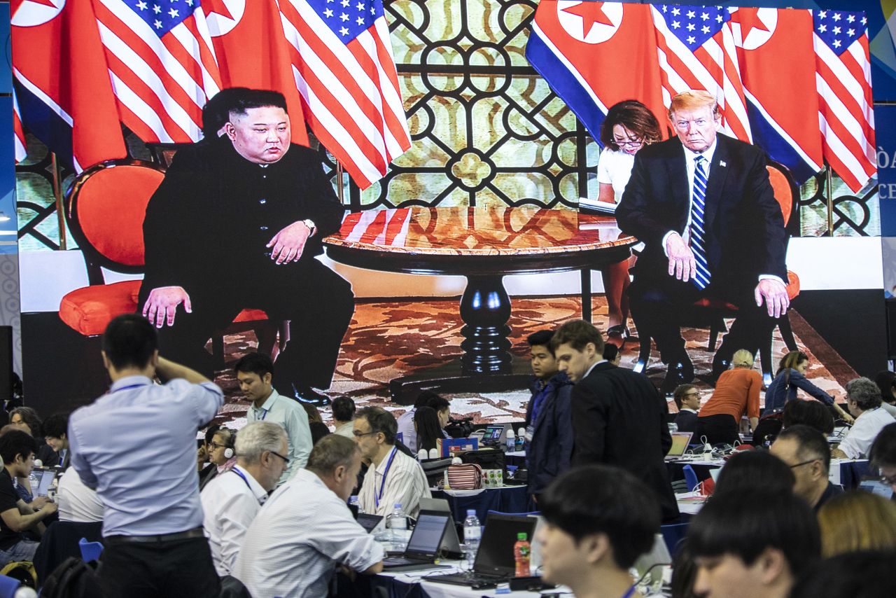 A screen shows video of Kim and Trump as members of the press work at a media center in Hanoi on February 28.