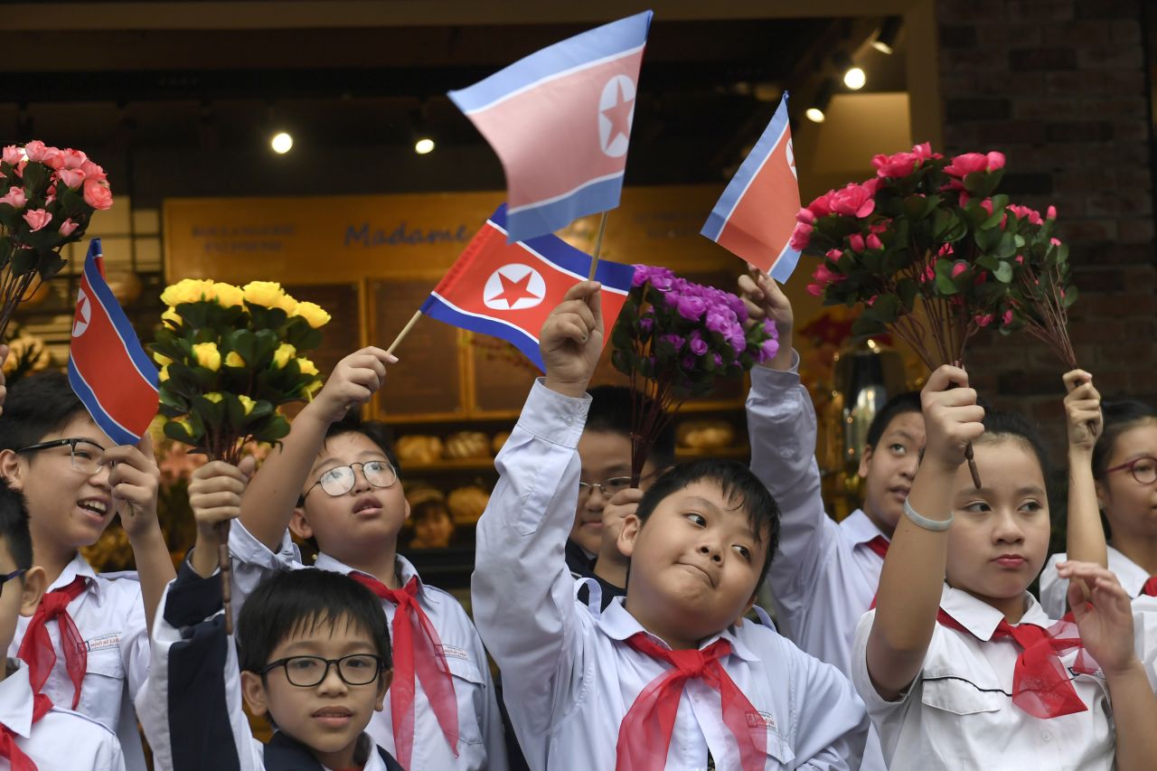 Schoolchildren gather along the streets of Hanoi to see Kim's motorcade on February 28.