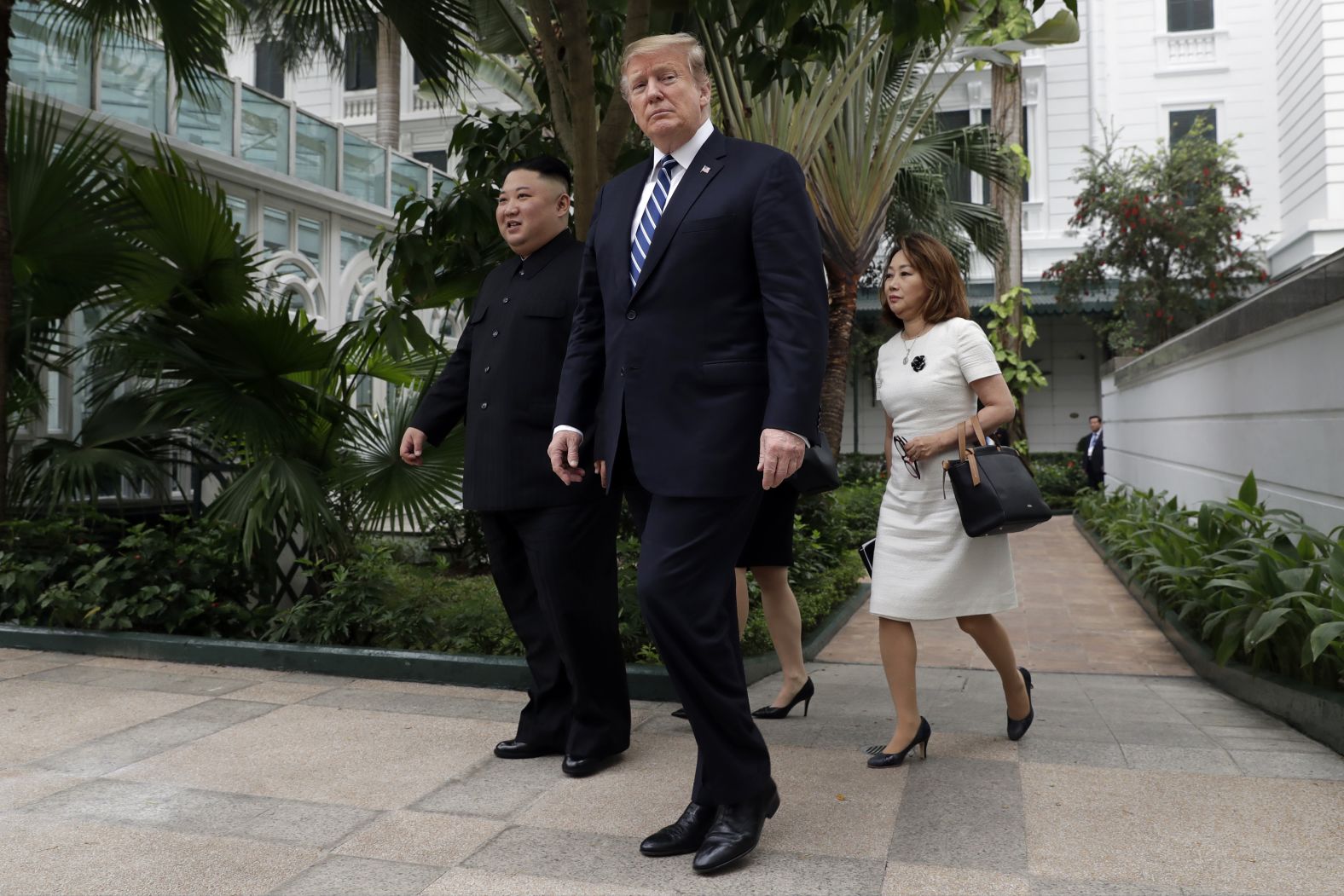 Trump and Kim are trailed by interpreters as they take a walk together at the Hotel Metropole in Hanoi on February 28.