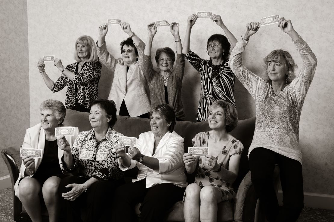 The Original Nine recreate their iconic photo from 1970 in 2012, with Julie Heldman (bottom right), who was not in the original image, replacing her mother. The women are holding one-dollar bills, which commemorate the symbolic professional contracts they signed in order to affirm their commitment to the Virginia Slims Circuit.