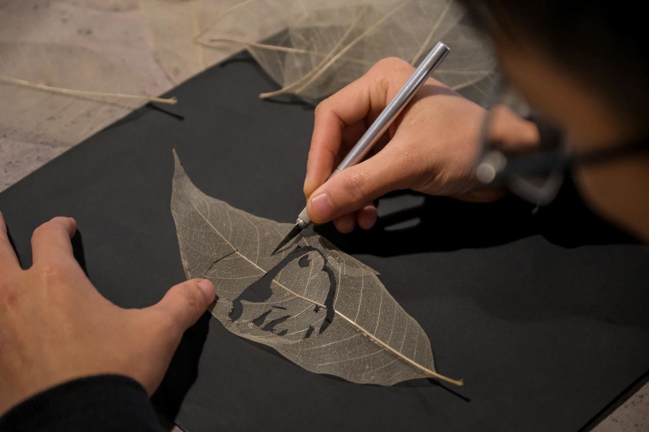 An artist at the Hanoi craft workshop Hatolo cuts into to dried leaves to make portraits of US President Donald Trump and North Korean leader Kim Jong-un in honor of Hanoi summit.