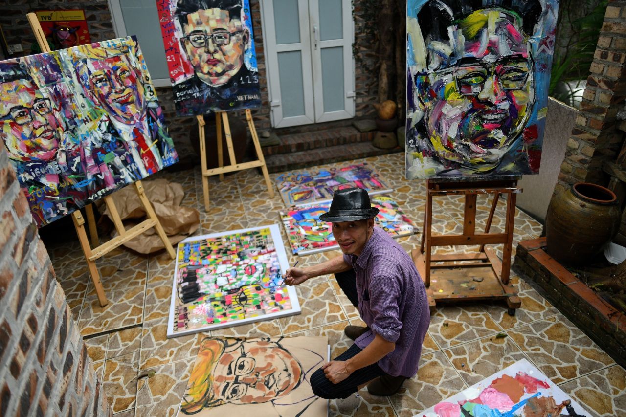 Artist Tran Lam Binh poses with the portraits of US President Donald Trump and North Korean leader Kim Jong Un at a cafe in Hanoi.