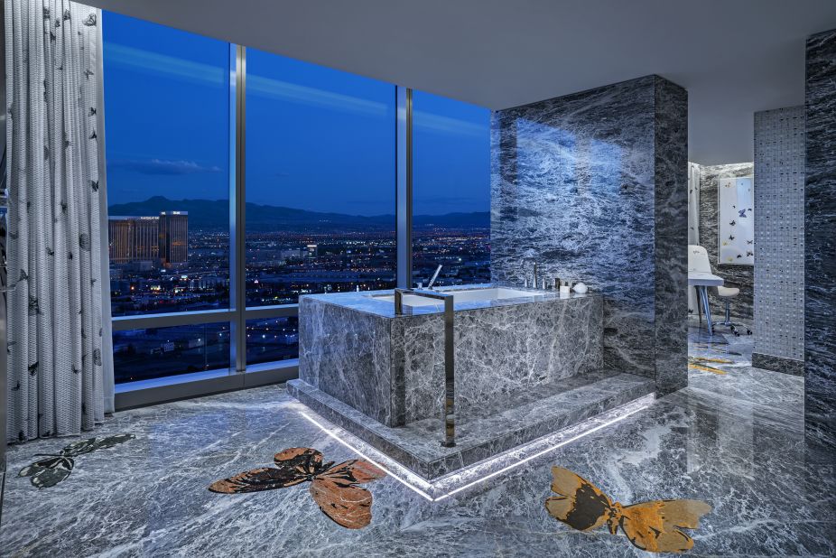 <strong>Tub with a view:</strong> Gray marble is used throughout the Empathy Suite. A mammoth soaking tub area is surrounded by Hirst butterflies and floor-to-ceiling Vegas views.