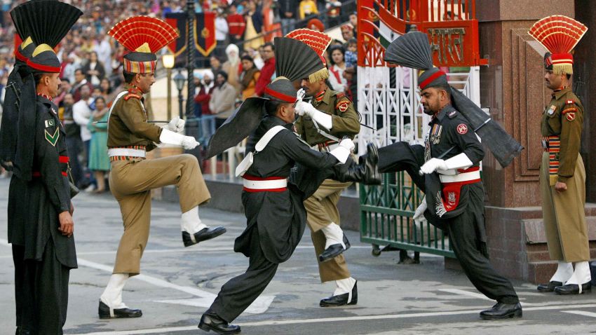 TO GO WITH AFP STORY "Pakistan-vote-India-peace" by Charlie McDonald-Gibson In this picture taken on February 20, 2008 at the Wagah border post with India, some 30 km from Lahore, Pakistani honour guards (black uniforms) and Indian rangers (background) take part in the daily flag-lowering ceremony.  Every evening as dusk falls on the India-Pakistan border post near Lahore, crowds gather on either side of the frontier and scream slogans at each other in a choreographed show of bravado. India on February 20 welcomed the elections in Pakistan and said it hoped to see fresh talks with its nuclear-armed South Asian rival.           AFP PHOTO/LIU Jin (Photo credit should read LIU JIN/AFP/Getty Images)