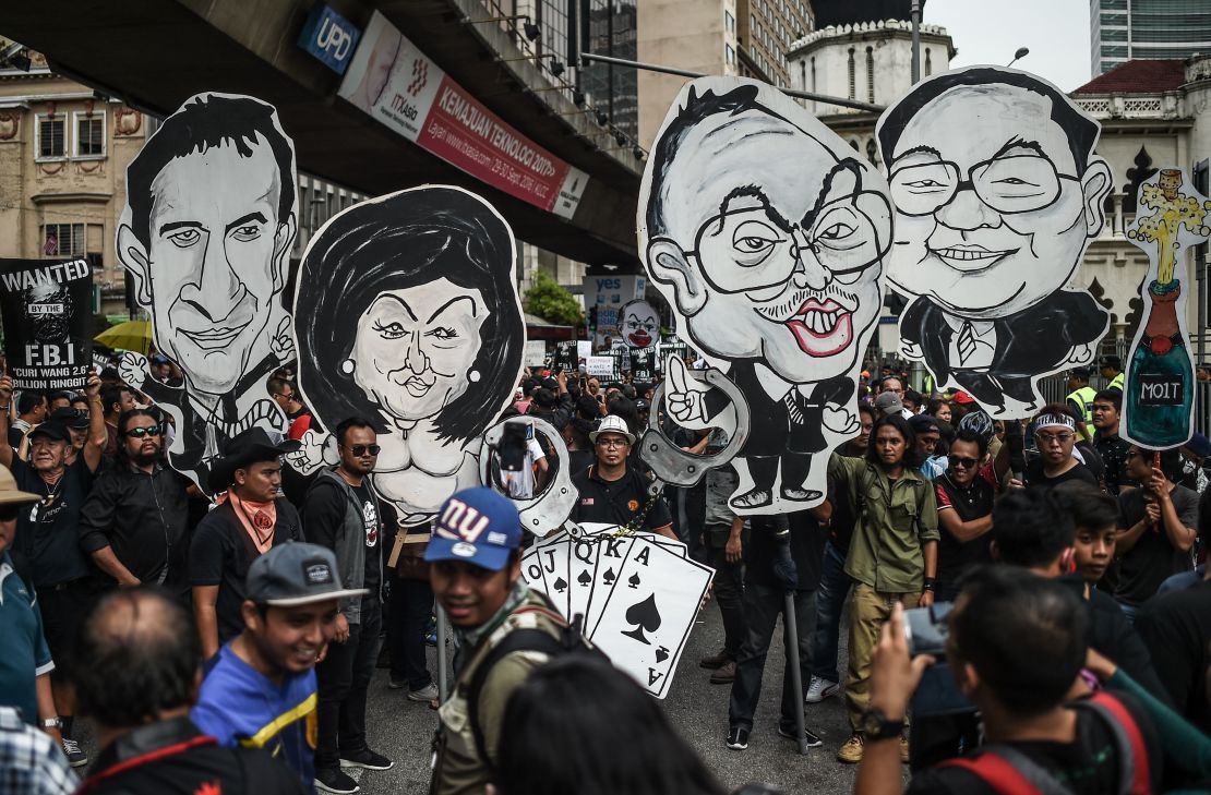 Activists hold up caricatures of Najib Razak and Rosmah Mansor (center). Political art became a key tool of protest in Malaysia during Najib's rule. 