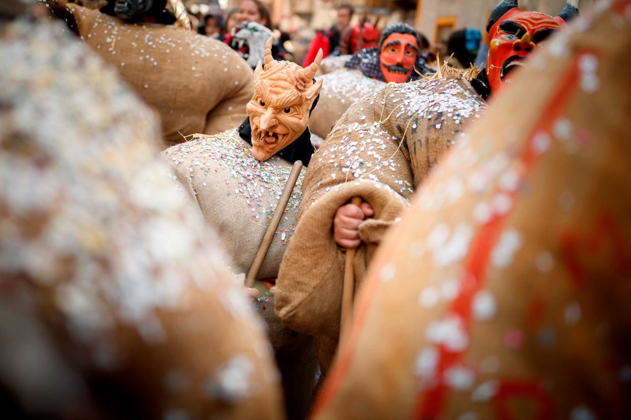 <strong>Evolene, Switzerland:</strong> Men dressed with traditional "straw man" costumes and devil or sorcerer masks parade in their village on Sunday, March 3. The straw men represent the spirits of ancestors believed to haunt the region.