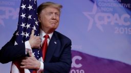 U.S. President Donald Trump hugs American flag at the Conservative Political Action Conference (CPAC) annual meeting at National Harbor near Washington, U.S., March 2, 2019. REUTERS/Yuri Gripas