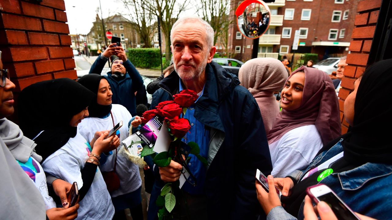 Labour Party leader Jeremy Corbyn is presented with some flowers as he arrives at the Finsbury Park Mosque in London on March 3, 2019.