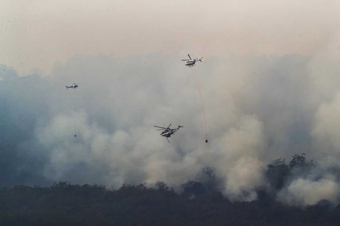 Helicopters drop water on a bushfire near Yiinnar in Gippsland, Australia, on Monday.