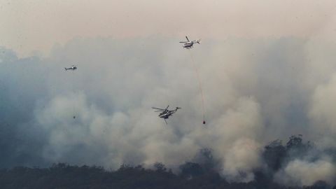 Helicopters drop water on a bushfire near Yiinnar in Gippsland, Australia, on Monday.
