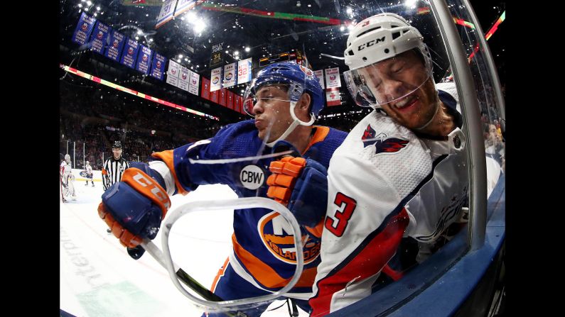 Tom Kuhnhackl of the New York Islanders, left, checks Nick Jensen of the Washington Capitals during their game on March 1, in Uniondale, New York.