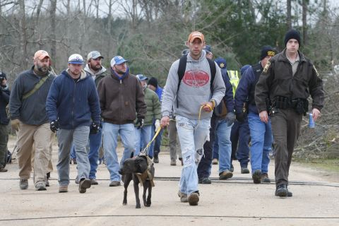 A search-and-rescue team walks past damage in Beauregard.