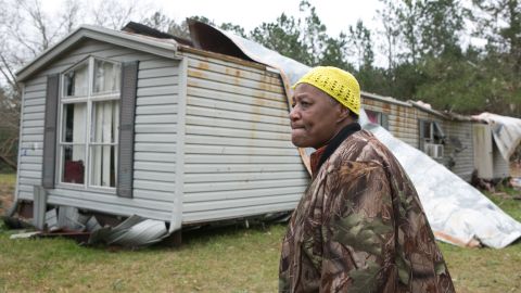 Christine Richardson stands in front of her damaged house in Beauregard on March 4.