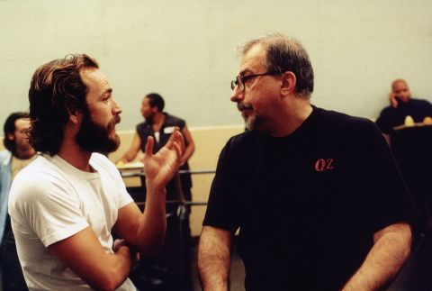 Perry talks to "Oz" creator Tom Fontana on the set of the TV show in 2001.