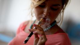 Chloe Lamb enjoys an electronic cigarette at the Vapor Shark store on September 6, 2013 in Miami, Florida.  E-cigarette manufacturers have seen a surge in popularity for the battery-powered devices that give users a vapor filled experience with nicotine and other additives, like flavoring.