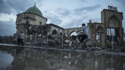 A resident rides a bicycle past the Al Nouri Mosque in the Old City of Mosul, Iraq, on Monday, Nov. 5, 2018. More than a year after the brutal fighting that liberated the city ended, and a devastating air campaign that mostly flattened it, much of Mosul lies in ruins. Few residents have returned and there is little commercial activity other than the destruction of devastated buildings and scavenging for metal. Photographer: Victor J. Blue/Bloomberg via Getty Images