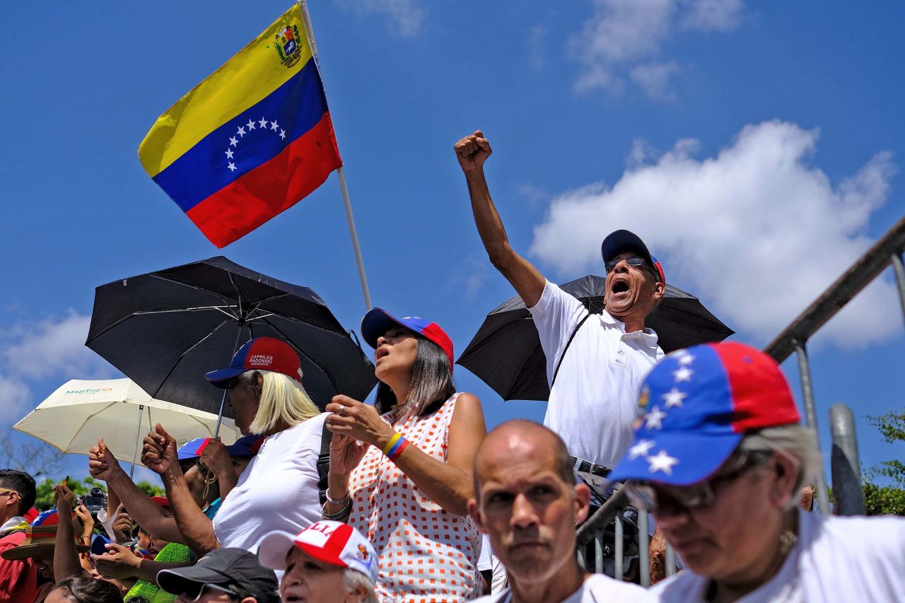 Supporters of Venezuelan opposition leader Juan Guaido wave a Venezuelan flag as they wait for him to make an appearance in the country's capital of Caracas on Monday, March 4.