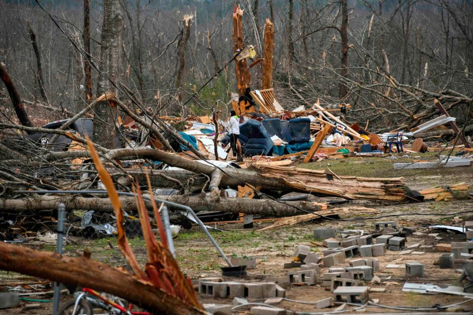 Brittney Downs looks through the debris of a family member's destroyed home in Beauregard.