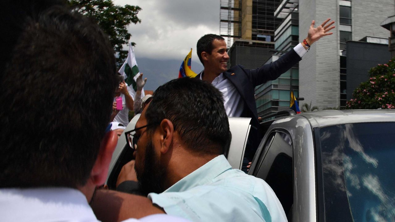 Venezuelan opposition leader and self-proclaimed acting president Juan Guaido greets supporters upon his arrival in Caracas on March 4, 2019. - Venezuela's opposition leader Juan Guaido was mobbed by supporters, media and the ambassadors of allied countries as he returned to Caracas on Monday, defying the threat of arrest from embattled President Nicolas Maduro's regime. Just before his arrival, US Vice President Mike Pence sent a warning to Maduro to ensure Guaido's safety. (Photo by Yuri CORTEZ / AFP)        (Photo credit should read YURI CORTEZ/AFP/Getty Images)
