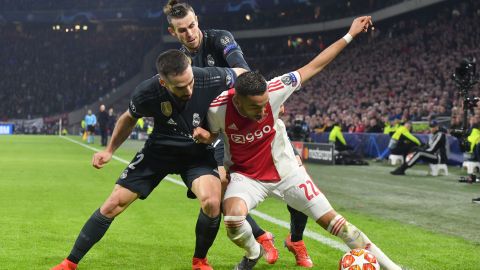 Ajax midfielder Hakim Ziyech (R) fights for the ball with Real Madrid's Spanish defender Dani Carvajal (L) and Real Madrid's Welsh forward Gareth Bale.