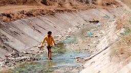 An Iraqi boy walks through a dried up irrigation dyke in the village of Sayyed Dakhil, some 300 kilometres (180 miles) south of Baghdad, on March 20, 2018. Drought is threatening agriculture and livelihoods in the area.