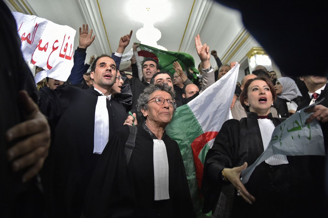 Algerian lawyers protest on February 25, holding up placards with slogans in Arabic that read: "The lawyers are with the people."