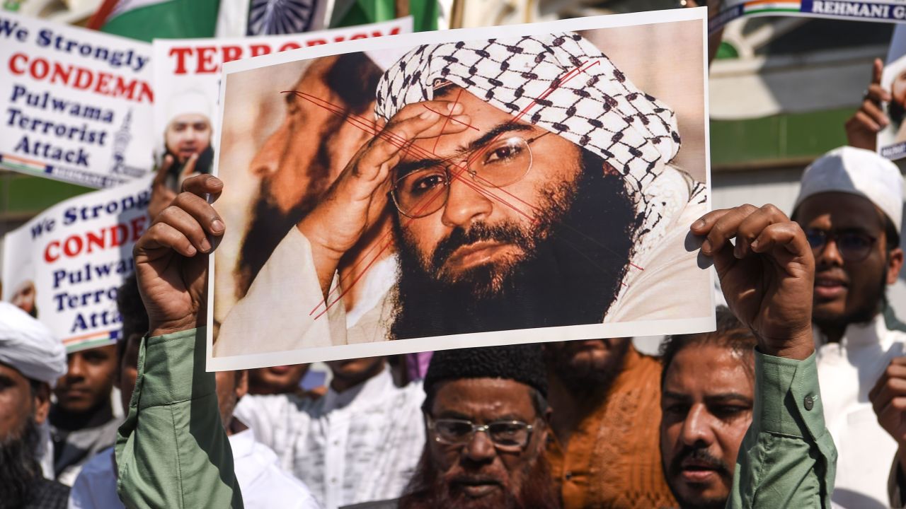 Indian Muslims hold a scratched photo of Jaish-e-Mohammad group chief, Maulana Masood Azhar, during a protest in Mumbai on February 15, 2019.